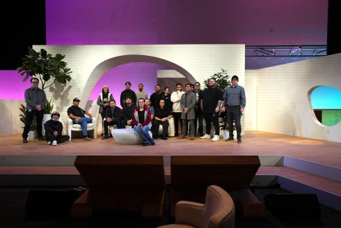 Meta Leadership Day 2025 team group photo on stage with curved white backdrop and purple lighting