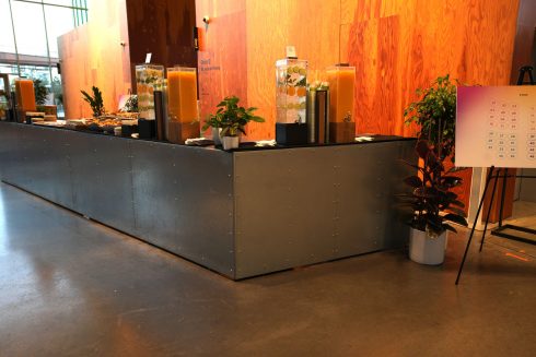 Meta Leadership Day 2025 catering station with juice dispensers, plants, and warm ambient lighting