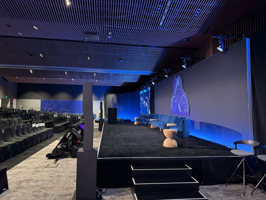 Microsoft Spear 2025 lounge area with modern seating, elevated stage, and branded wall graphics featuring blue lighting