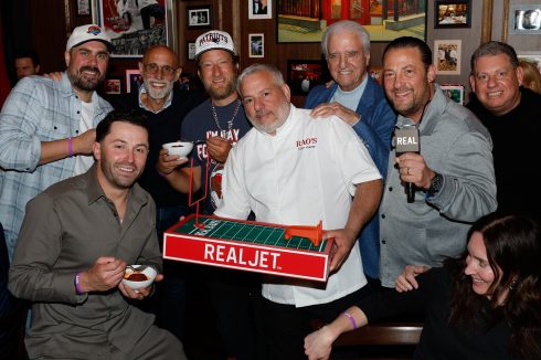 Group photo inside Rao's restaurant during Crucial Catch to Intercept Cancer event with NFL and REAL branding