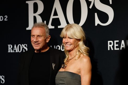 Joe Montana and guest posing on red carpet at Rao's Crucial Catch step and repeat banner with LIQUID 2 and REAL branding