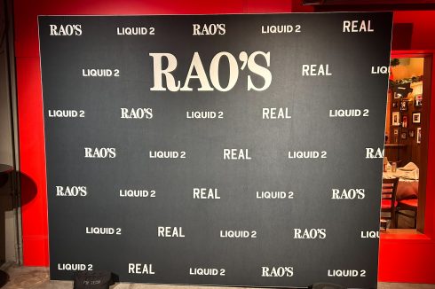 Rao's Crucial Catch step and repeat banner with LIQUID 2 and REAL branding inside restaurant venue